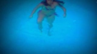 Frau spielt im Pool mit Düsen