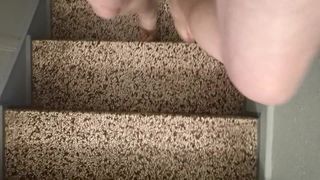 Het teefje naakt in doorzichtige pandolettes in het trappenhuis