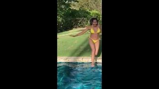 Padma Lakshmi in een bikini, springend in een zwembad