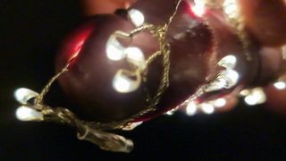 Weihnachtsbaum mit Lichterkette spritzt im Dunkeln ab