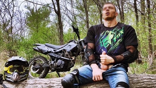 Hübscher Biker beim Reiten eines Motorrads im Wald wichst und kommt öffentlich