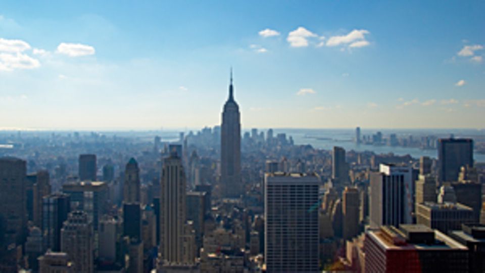 Ein Bild, über den Dächern von New York. Im Zentrum des Bildes ist das Empire State Building.