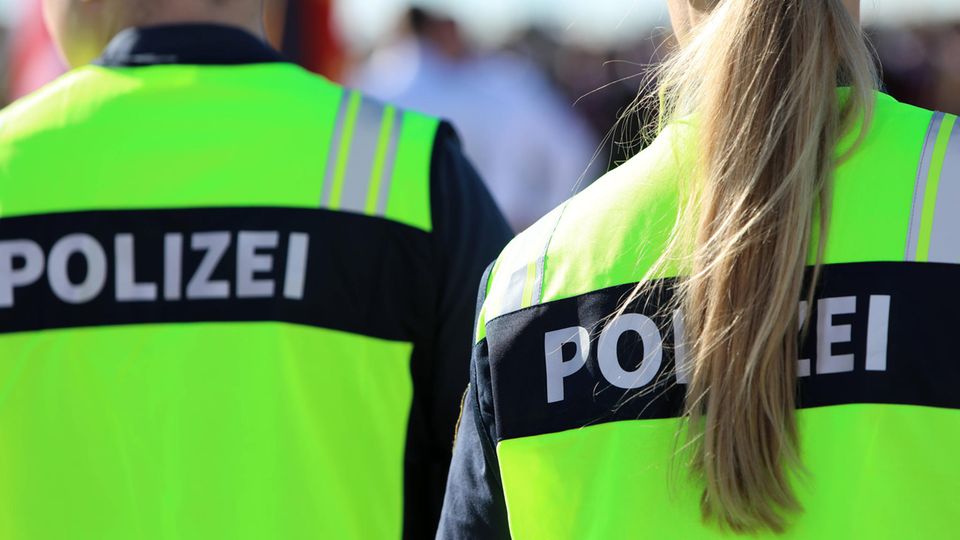 Ein Polizist und eine Polizistin stehen am Flughafen München nebeneinander