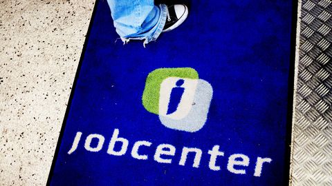 Eine Person steht auf einer Fußmatte mit der Aufschrift Jobcenter