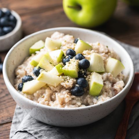 Schüssel mit Haferflocken-Porridge, Äpfel und Blaubeeren