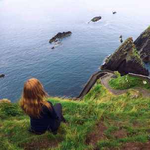 Kind blickt auf irische Küstenlandschaft
