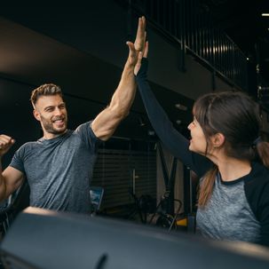 Frau und Mann, die sich im Fitnessstudio abklatschen