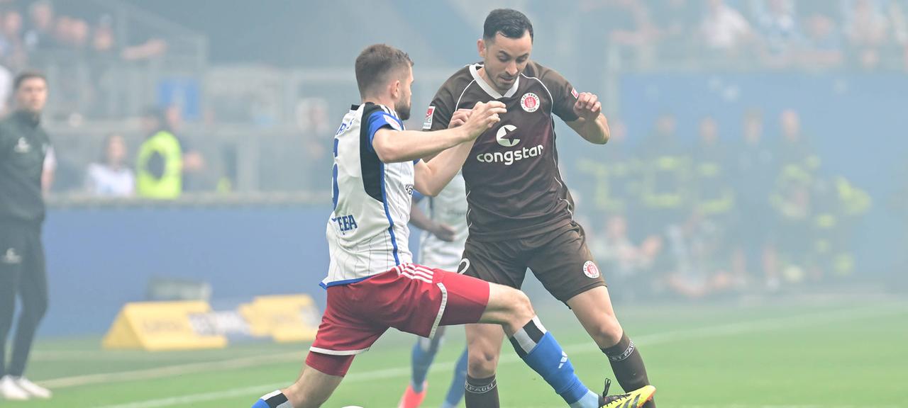 HSV-Spieler Lukasz Poreba und Manolis Saliakas vom FC St. Pauli kämpfen um den Ball