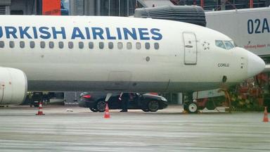 Der Geiselnehmer steigt mit seinem Kind auf dem Arm am Flughafen aus seinem Fahrzeug nahe einem Flugzeug.