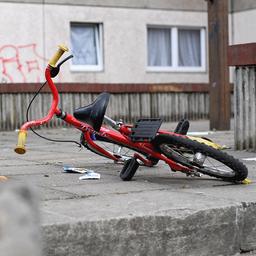 Ein Kinderfahrrad liegt in einem Aufgang zu einem Plattenbau.