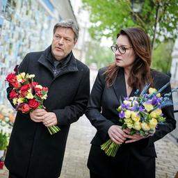 Robert Habeck und Julija Swyrydenko legen an einer Gedenkmauer für die im Krieg gefallenen Soldaten Blumen nieder.