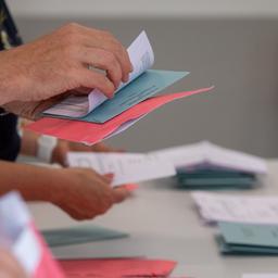 Wahlhelfer und Wahlhelferinnen öffnen im Klassenzimmer einer Schule in Magdeburg die Umschläge der Briefwahl