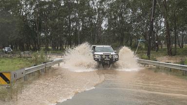 Ein Auto fährt über eine überschwemmte Straße in Vineyard in Sydney.