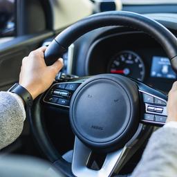 Eine Frau sitzt hinter dem Lenkrad eines Autos.