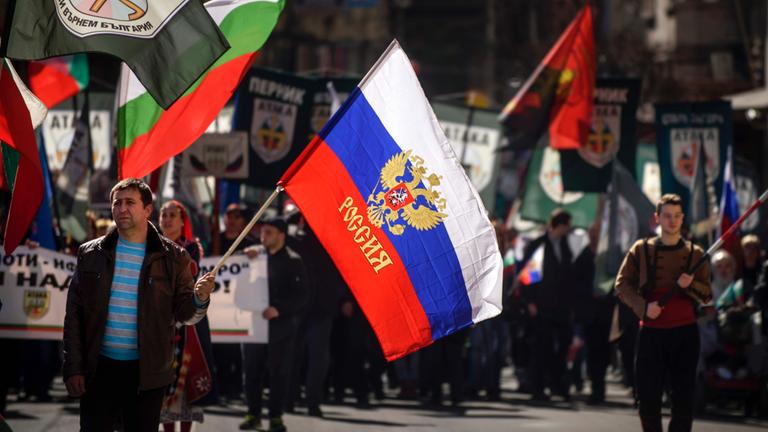 Bei einer Kundgebung zum bulgarischen Nationalfeiertag trägt ein Mann eine russische Flagge.