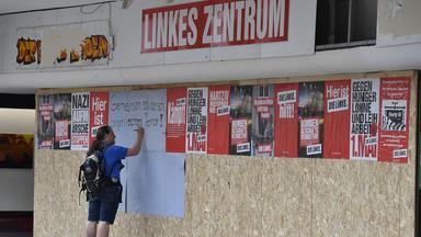 Ein Mann trägt sich 2022 am zerstörten Parteibüro der Linkspartei in Oberhausen in eine Unterschriftenliste ein.