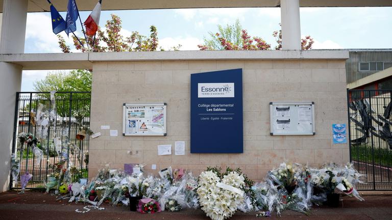Blumen liegen an einem Schuleingang in Frankreich, wo ein 15-Jähriger von Jugendlichen zu Tode geprügelt wurde. 