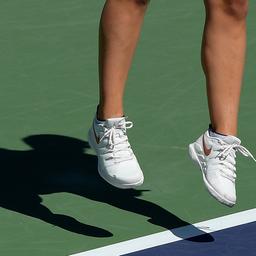 Der Schatten einer Tennisspielerin ist auf dem Tennisplatz zu sehen.