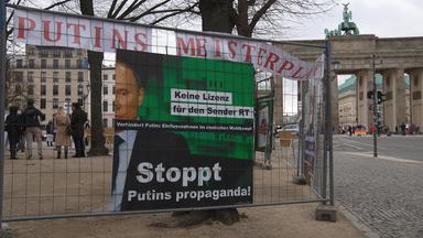 "Stoppt Putins Propaganda - Keine Lizenz für den Sender RT" steht auf einem Transparent unweit des Brandenburger Tores. 