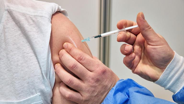 Ein Mann wird in einem Impfzentrum in Schleswig-Holstein gegen das Coronavirus geimpft