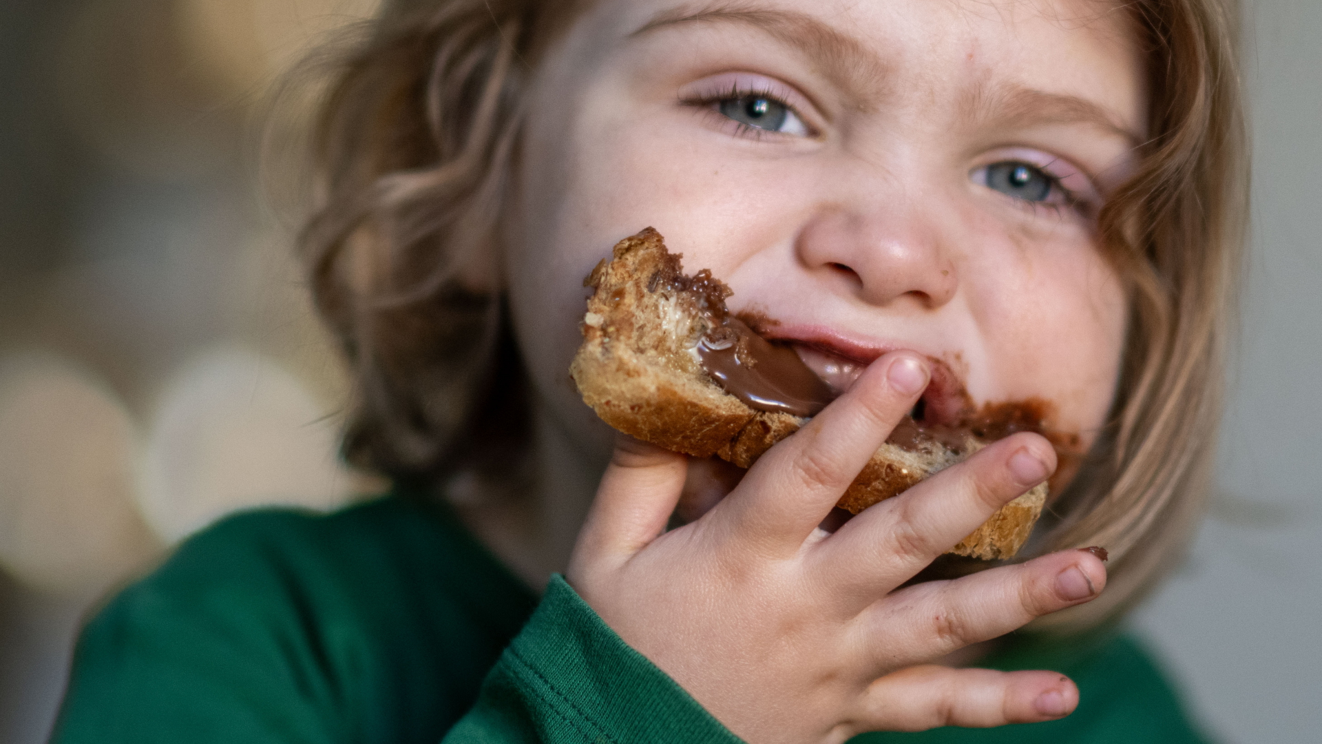 Ein Kind beißt in ein Nutella-Brot