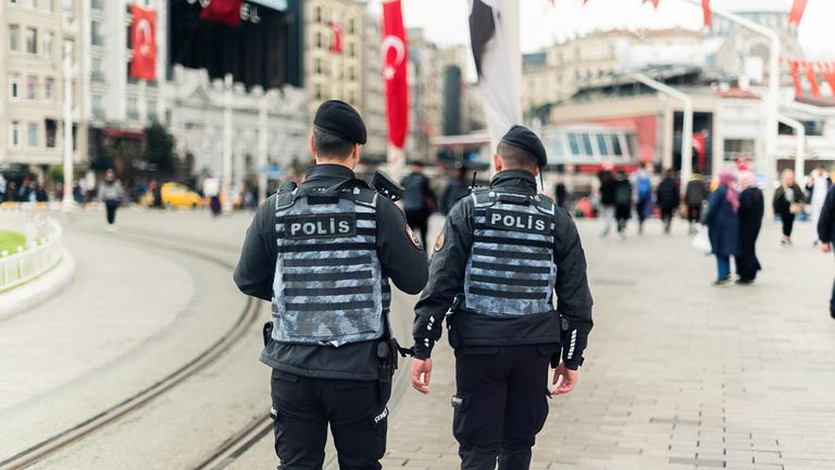 Zwei Polizisten gehen zu Fuß auf einer Straße in Istanbul.