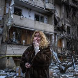 Eine Frau steht vor einem zerstörten Wohnhaus in der ukrainischen Hauptstadt Kiew.