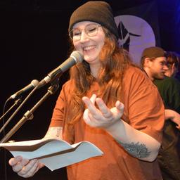 Die Poetry Slammerin Selina Seemann steht im Statt-Café Kiel am Mikrofon und spricht.