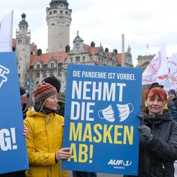 Teilnehmerinnen einer Demonstration von Gegnern der Coronamaßnahmen der Bundesregierung in Leipzig halten Schilder mit der Aufschrift "Nein zum Impfzwang" und "Nehmt die Masken ab".