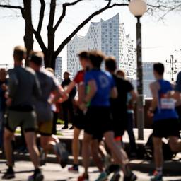 Menschen laufen bei dem Hamburg-Marathon mit. Diese Menschen laufen am Hafen.