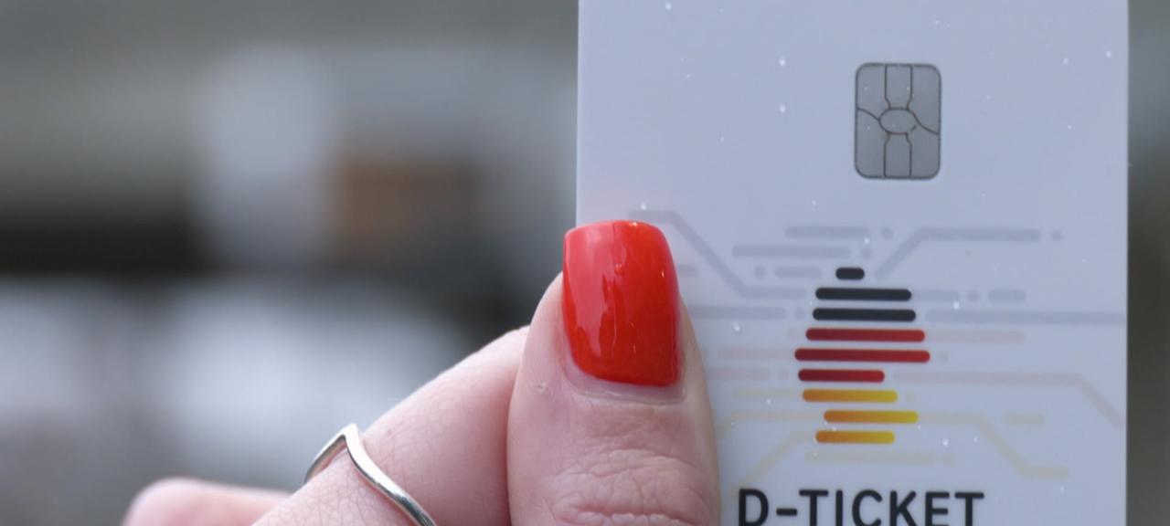 Eine Person hält ein Deutschlandticket in der Hand