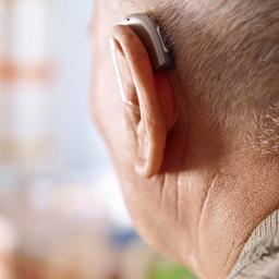 Ein älterer Mann mit Hörgerät von hinten fotografiert.
