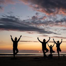 Mitglieder einer Yoga-Klasse trainieren an der Cayton Bay in Scarborough (Großbritannien) während die Sonne aufgeht.