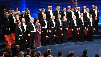 Die Nobelpreisträger haben sich von ihren Stühlen erhoben.