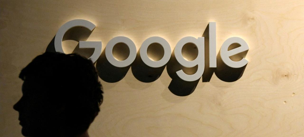 Der Umriss eines Menschen vor einem Schriftzug des Google-Konzerns