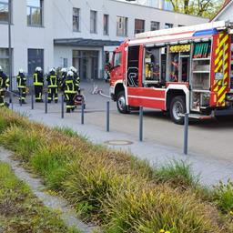 Feuerwehrleute und ein feuerwehrauto stehen vor der Helios-Klinik in Schleswig.