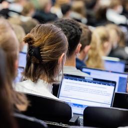 Eine Studentin sitzt mit ihrem Laptop in einem Hörsaal.