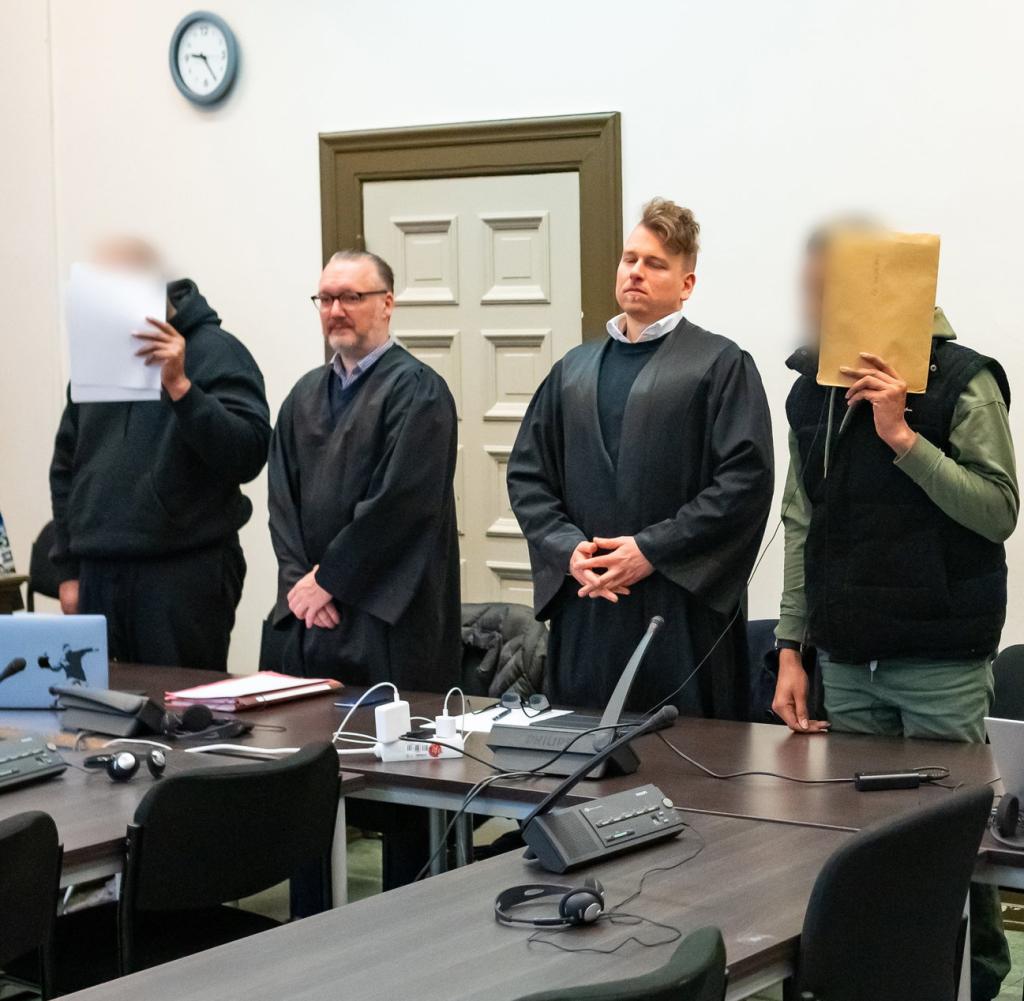 Die Angeklagten mit ihren Anwälten vor Beginn des Prozesses. Rechts: der deutsch-türkische Komplize der beiden Männer von den Bahamas