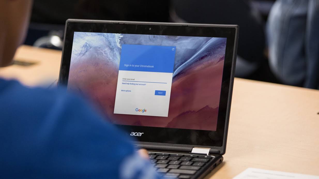 책상에서 Google 로그인 화면이 표시된 Chromebook을 사용하는 학생의 사진을 자른 이미지