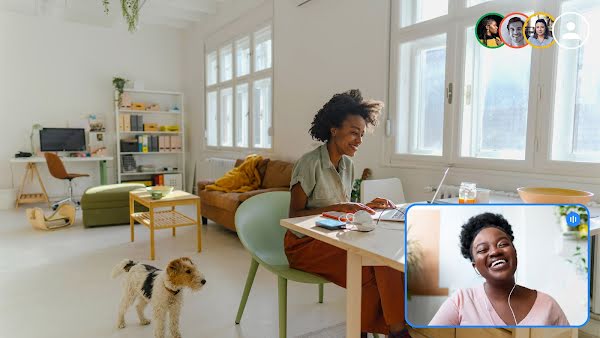 Zwei Frauen unterhalten sich per Videoanruf. Eine Frau sitzt an einem Schreibtisch. In ihrer NÃ¤he befindet sich ein Hund. Die andere Frau ist lÃ¤chelnd im Videoanruffenster zu sehen.