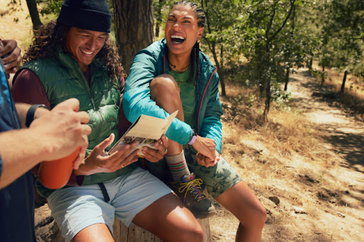 Some hikers laugh while talking and looking at a map.