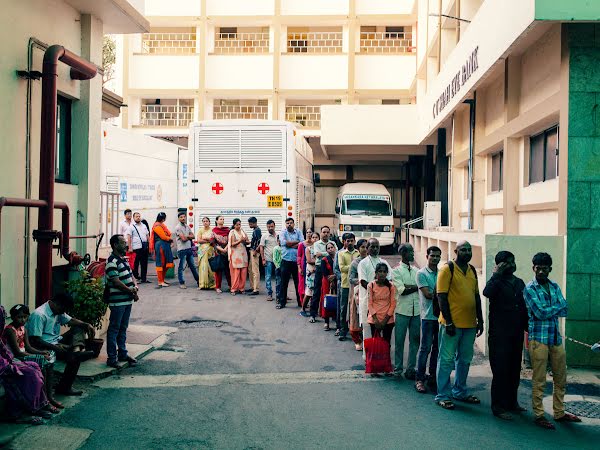 Patienten stehen vor dem Sankara Nethralaya Eye Hospital Schlange.