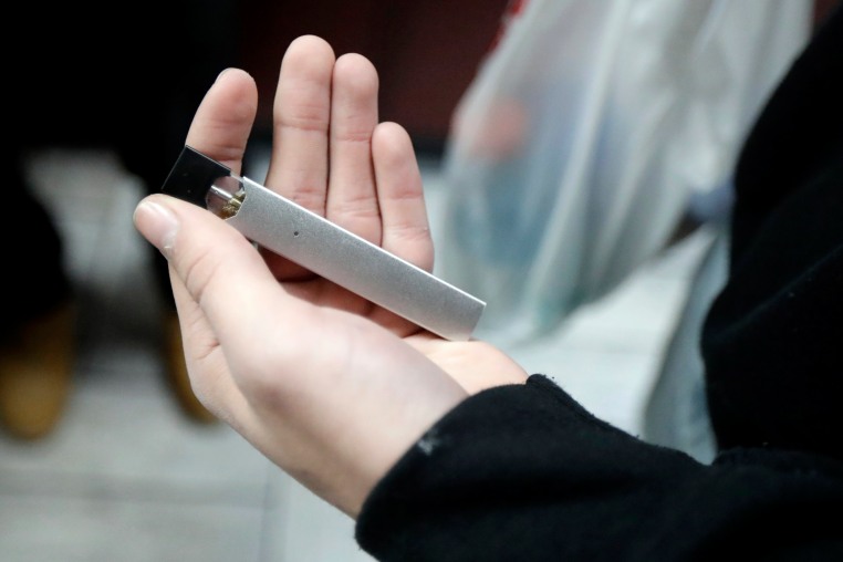 A man displays his Juul electronic cigarette while shopping at a convenience store in Hoboken, N.J.