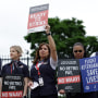 American Airlines flight attendants hold signs and picket outside the White House