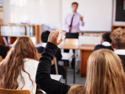 Female Student Raising Hand To Ask Question In Classroom. (monkeybusinessimages/iStock/Get