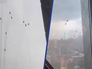Chinezen bungelen aan hoog gebouw na harde wind