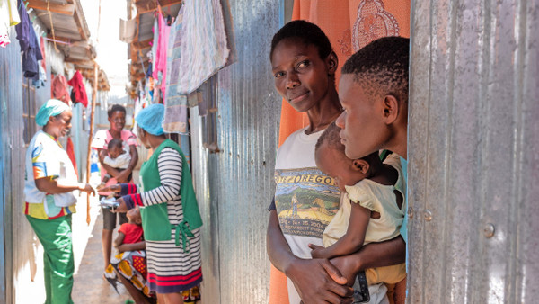 Hausbesuch: Gaudenica Salano und Beth Mueni (links hinten) sprechen mit ihren Patientinnen im Slum Njoguini.