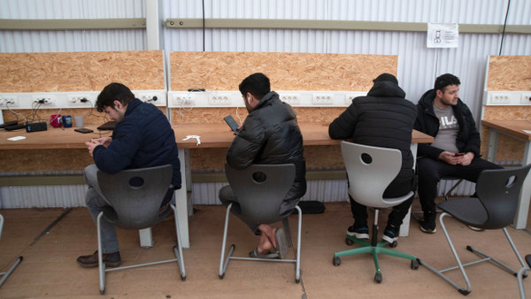 Flüchtlingsunterkunft im hessischen Bensheim: Flüchtlinge laden ihre Handys auf.