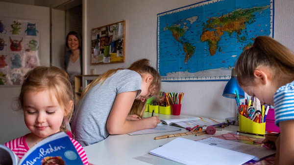 Auch beim Homeschooling gibt es Hausaufgaben: Charlotte, 12 Jahre, und Franziska, 10 Jahre, arbeiten in ihrem Tempo. Matilda, 3 Jahre, leistet Gesellschaft, und Mutter Stephanie Machnik schaut nach dem Rechten.