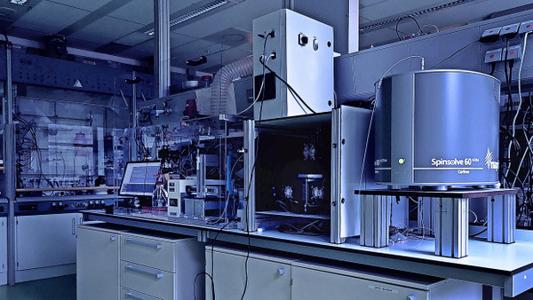Künstlicher Chemiker im Labor: Die KI im Computer links steuert die Geräte rechts und wertet die Versuche aus.